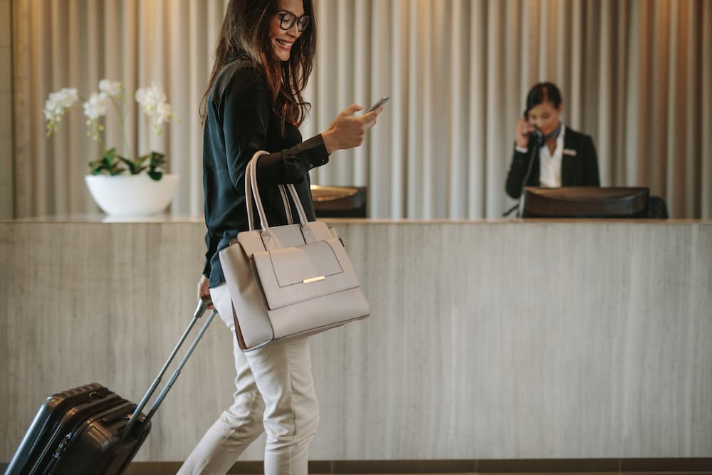 Happy guest in a luxurious hotel lobby, symbolizing successful hotel advertising