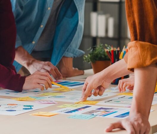 Team arbeitet gemeinsam an Marketing-Strategien mit Diagrammen und Notizen auf einem Tisch